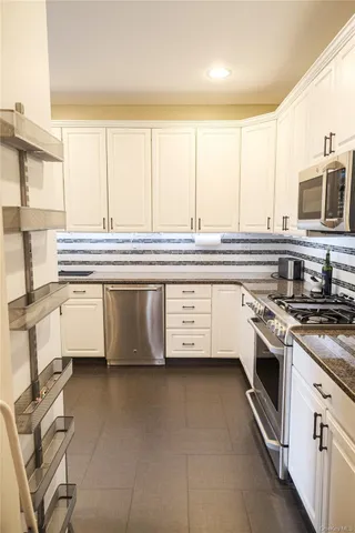 a kitchen with stainless steel appliances a stove sink and cabinets