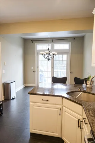 a kitchen with granite countertop a sink cabinets and wooden floor
