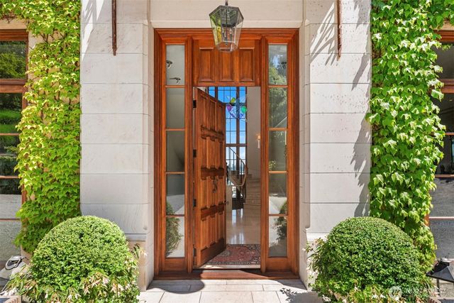 a view of a brick house with a large windows and plants