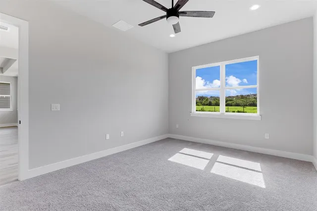 en empty room with window and ceiling fan