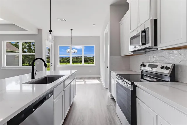 a kitchen with stainless steel appliances a sink stove and microwave