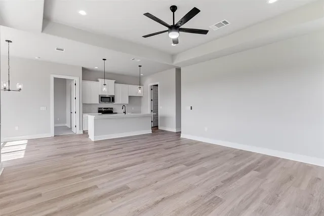 a view of a kitchen with wooden floor and a ceiling fan