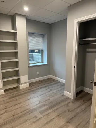 an empty room with wooden floor and window