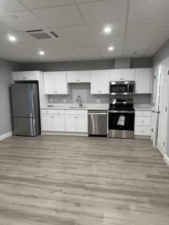 a large kitchen with stainless steel appliances granite countertop a stove and a refrigerator
