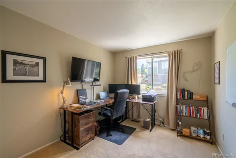 a view of a workspace with furniture and a window