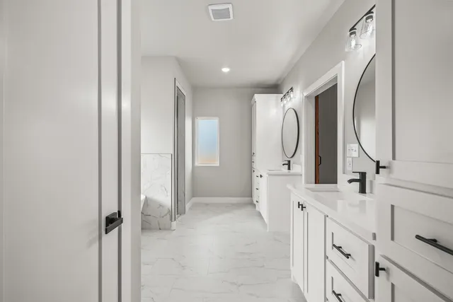 a bathroom with a double vanity sink mirror and a shower