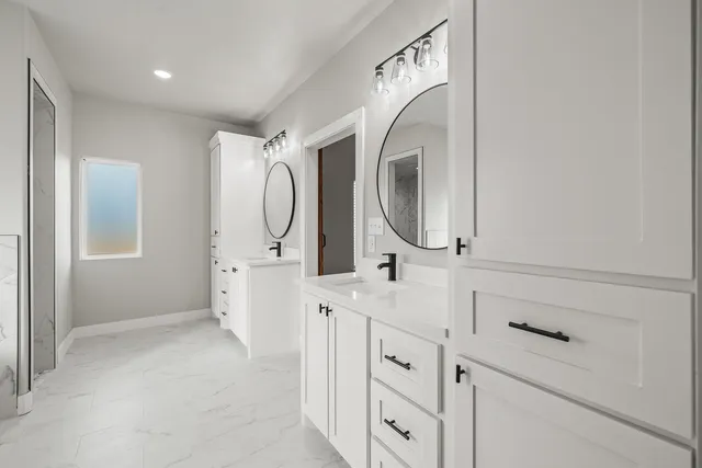 a bathroom with a double vanity sink mirror and shower