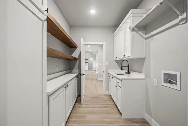 a kitchen with white cabinets and sink