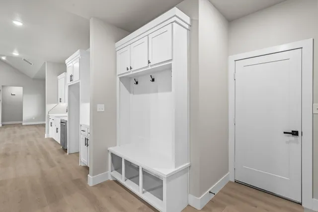 a utility room with white cabinets and stainless steel appliances
