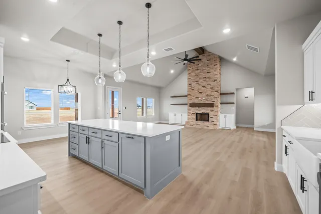 an empty room with windows and fireplace