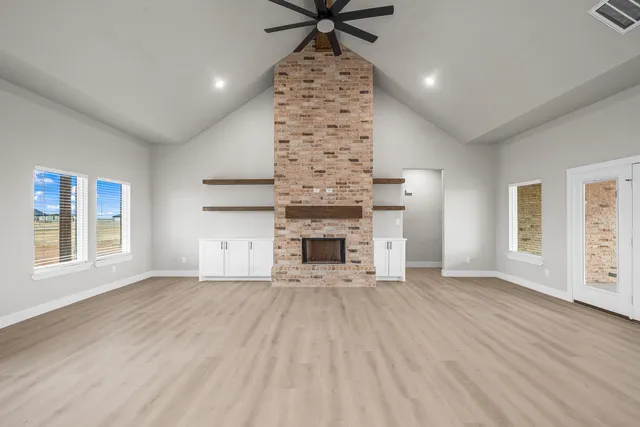 an empty room with windows and fireplace