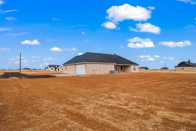a front view of house with yard and ocean