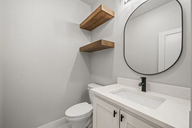 a bathroom with a sink mirror and toilet
