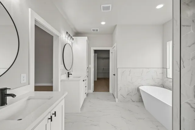 a bathroom with a granite countertop sink mirror and bathtub