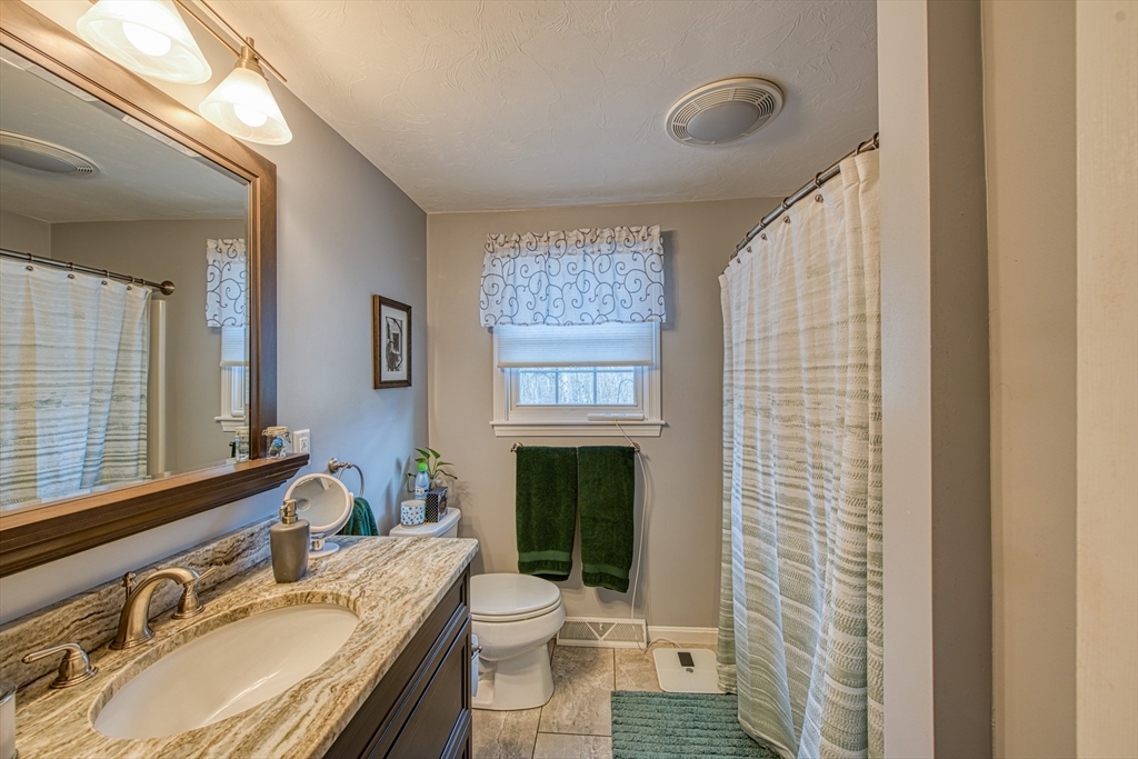 10 Colby Road Bridgewater, MA 02324 - Photo 32 of 42 a bathroom with a granite countertop sink toilet a mirror and shower
