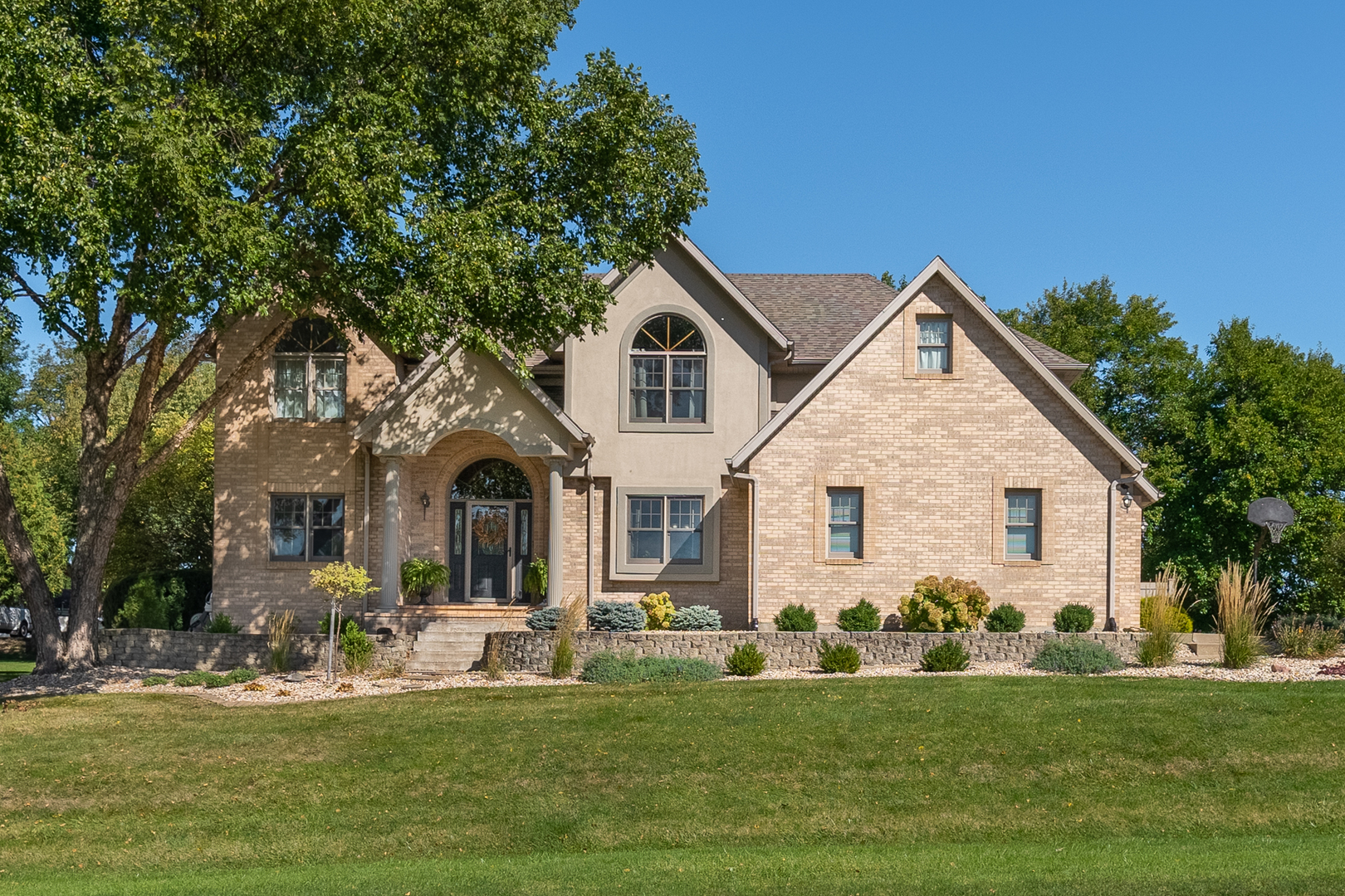 a front view of a house with a garden and yard