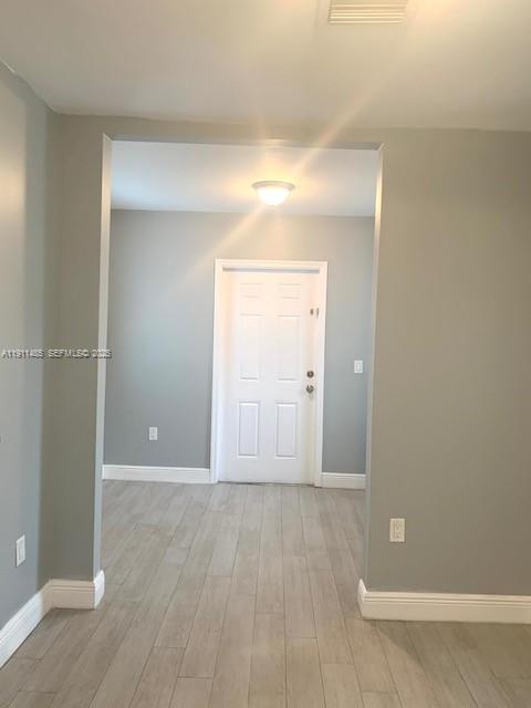 4126 Northwest 3rd Avenue, Unit 4126 Miami, FL 33127 - Photo 5 of 29 an empty room with wooden floor and mirror