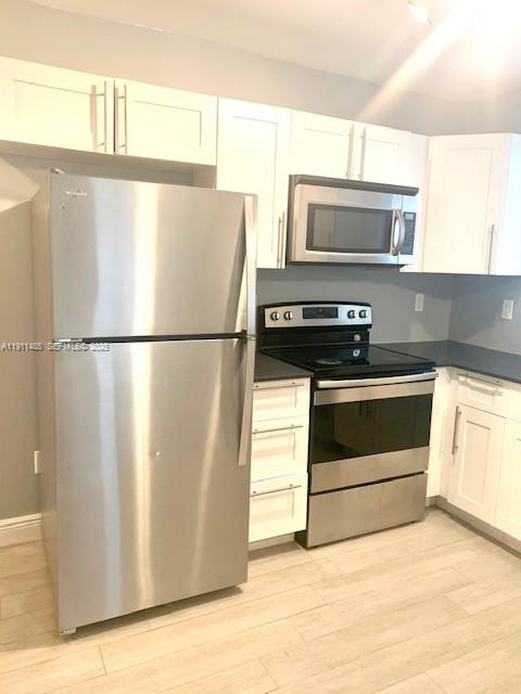 4126 Northwest 3rd Avenue, Unit 4126 Miami, FL 33127 - Photo 9 of 29 a white refrigerator freezer and a stove sitting inside of a kitchen