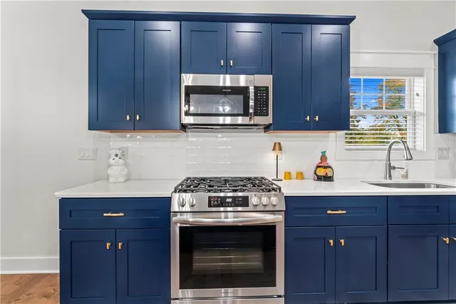 a kitchen with granite countertop wood cabinets stainless steel appliances and a sink