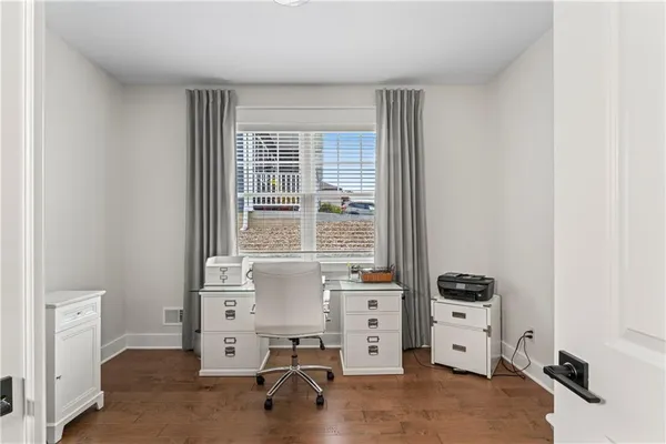 a view of a workspace with furniture and a window