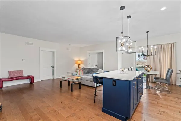 a view of a dining room and livingroom with furniture wooden floor a chandelier