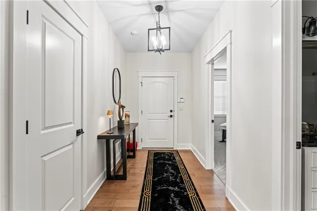 a view of a hallway with wooden floor and staircase