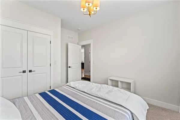 a bedroom with a bed and a chandelier