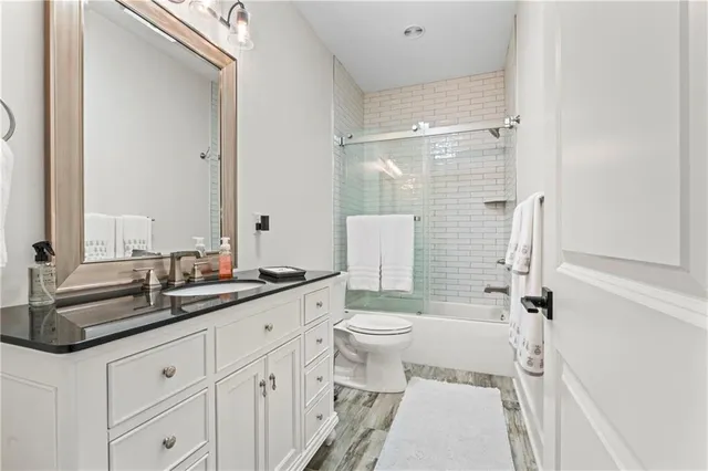 a bathroom with a double vanity sink toilet mirror and shower