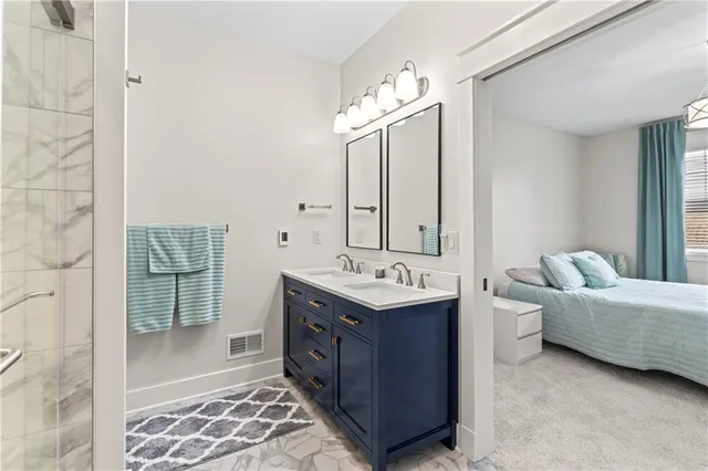 a bathroom with a double vanity sink mirror and bathtub