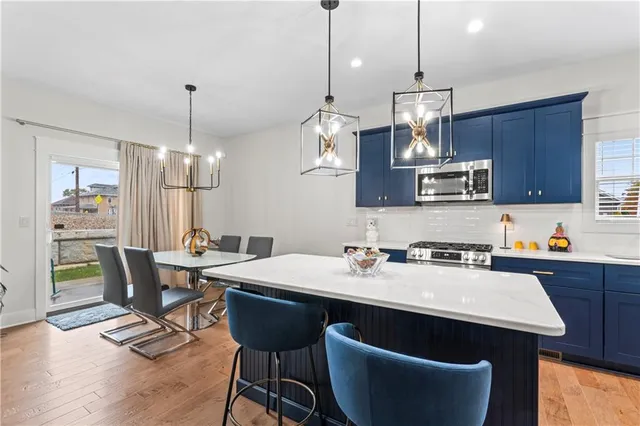 a kitchen with a dining table chairs and wooden floor