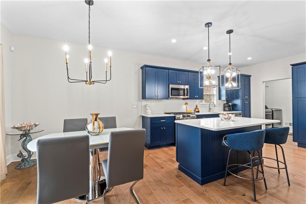 16 Barrington Court Monaca, PA 15061 - Photo 6 of 36 a kitchen with kitchen island a dining table chairs and a chandelier