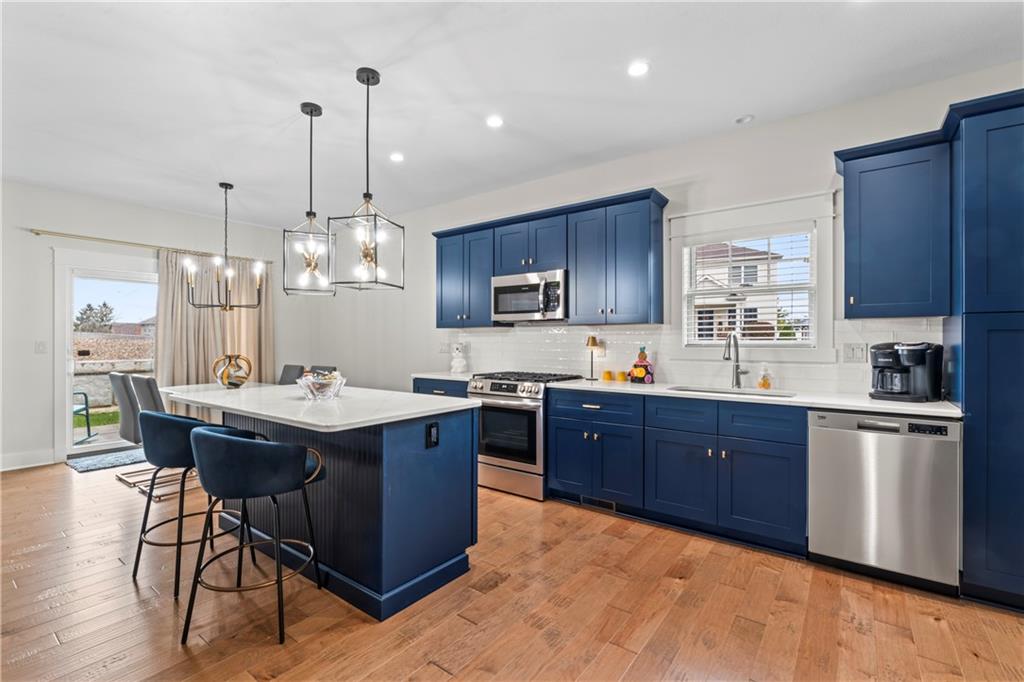 16 Barrington Court Monaca, PA 15061 - Photo 7 of 36 a kitchen with stainless steel appliances granite countertop wooden cabinets a sink a stove a dining table and chairs
