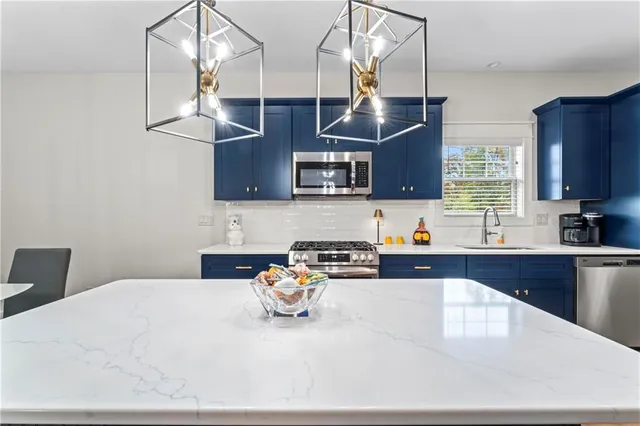 a kitchen with stainless steel appliances granite countertop a sink a stove and a microwave