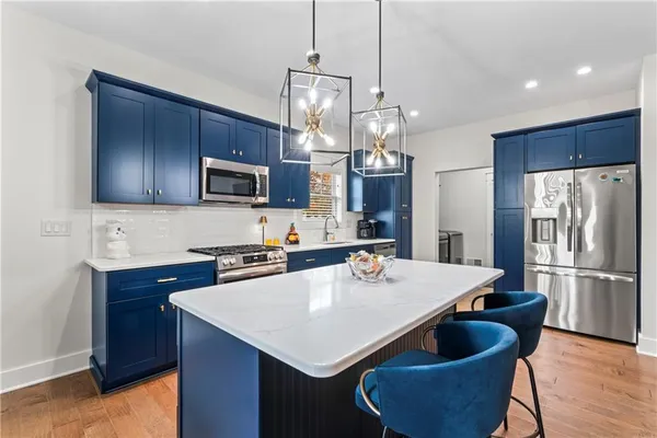 a kitchen with stainless steel appliances granite countertop a sink dishwasher a refrigerator a stove a refrigerator and island