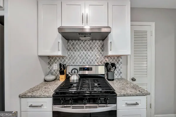 a stove top oven sitting inside of a kitchen