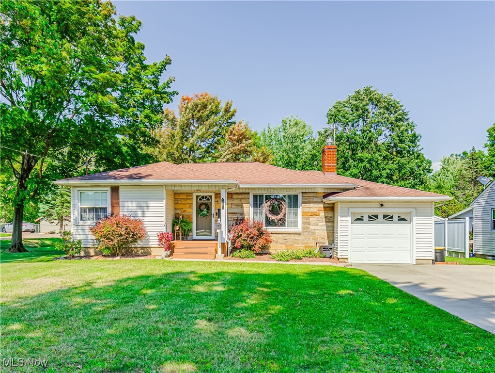 Ranch-style home with a front lawn and a garage