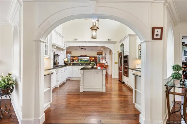 a kitchen with stainless steel appliances granite countertop a stove top oven a sink dishwasher a refrigerator and cabinets with wooden floor