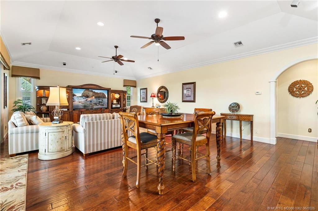 3192 Southeast Fairway West Stuart, FL 34997 - Photo 23 of 76 a view of a dining room and livingroom with furniture wooden floor a rug a chandelier