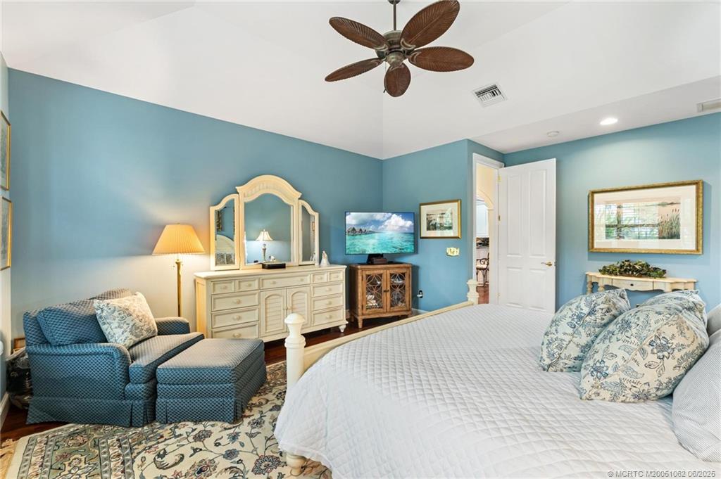 3192 Southeast Fairway West Stuart, FL 34997 - Photo 30 of 76 a bedroom with a bed and ceiling fan