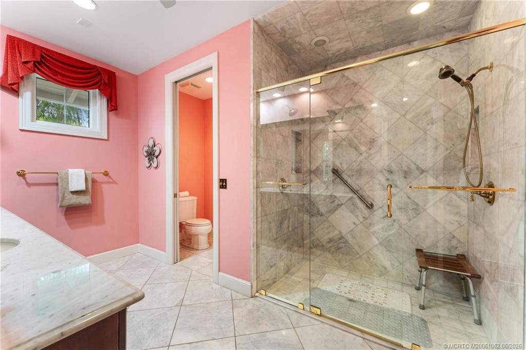 3192 Southeast Fairway West Stuart, FL 34997 - Photo 33 of 76 a bathroom with a granite countertop shower a sink and a mirror