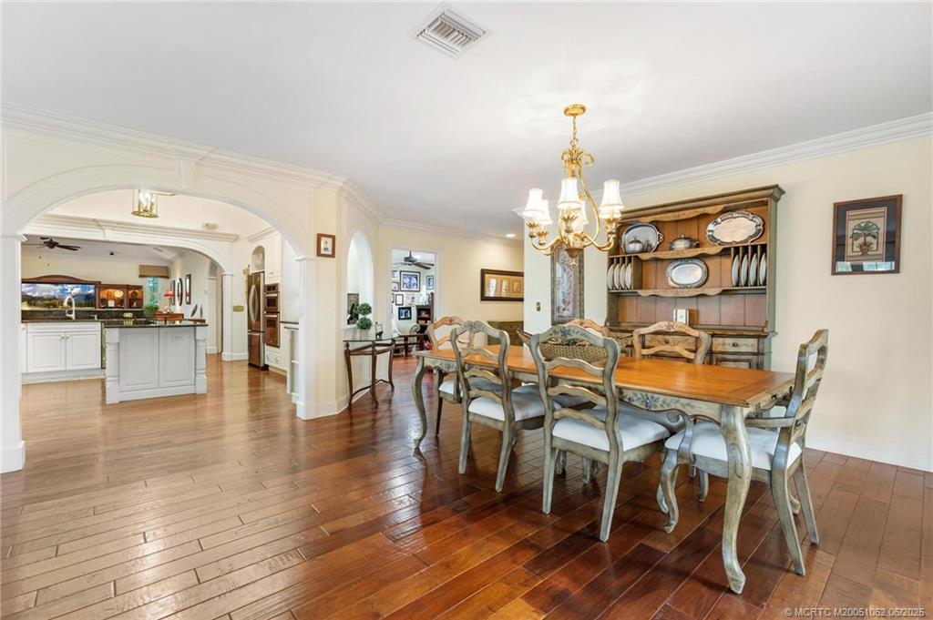 3192 Southeast Fairway West Stuart, FL 34997 - Photo 7 of 76 a view of a dining room with furniture and wooden floor
