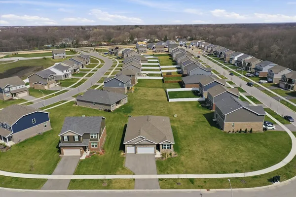 an aerial view of a house with a yard and lake view