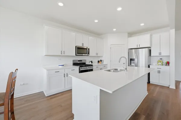 a kitchen with white cabinets and stainless steel appliances