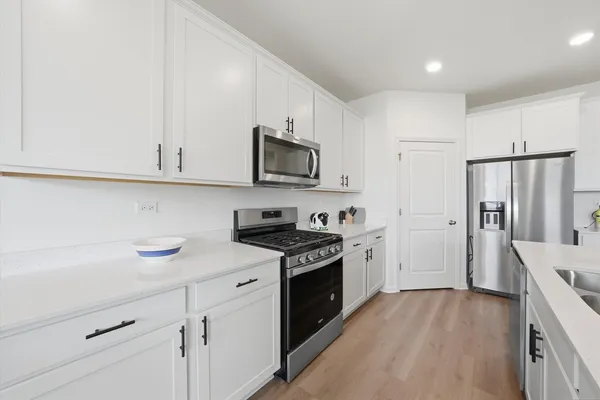 a kitchen with stainless steel appliances granite countertop a stove a sink and a refrigerator
