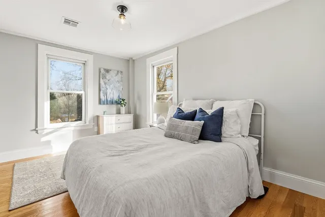 a large bed sitting in a bedroom next to a window