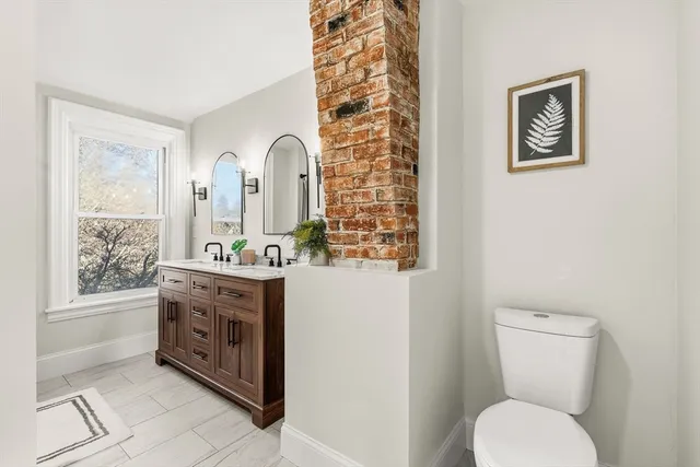 a bathroom with a toilet a sink and mirror