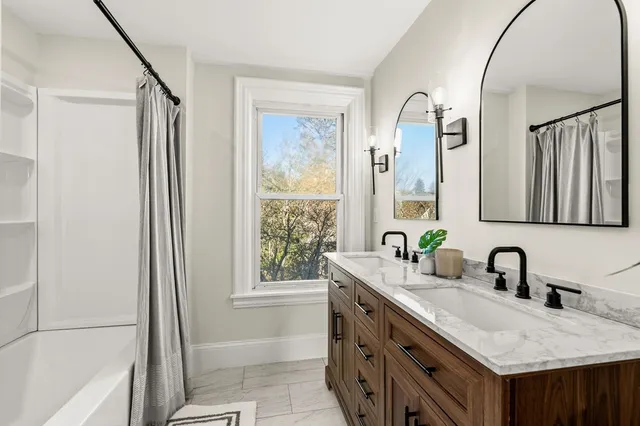 a bathroom with a granite countertop sink a mirror and a bathtub