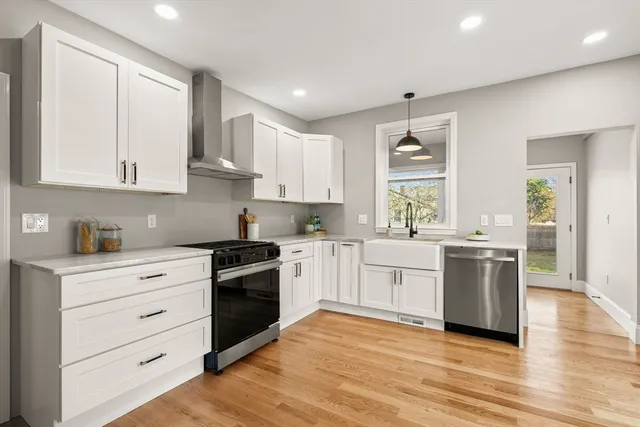 a kitchen with a white stove top oven and white cabinets