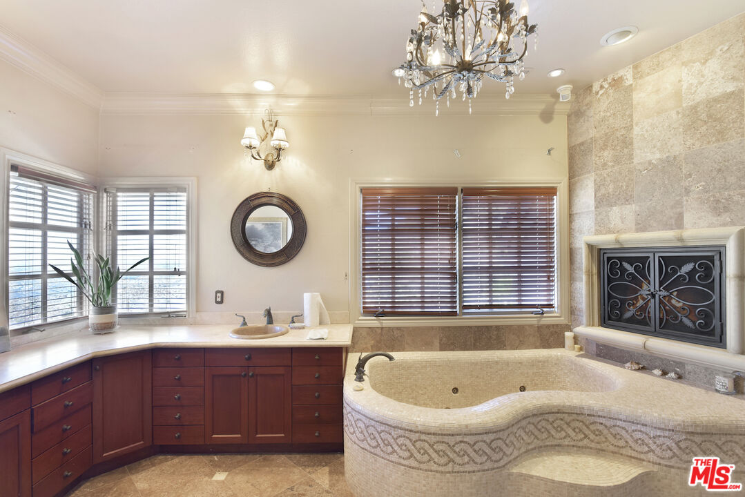 480 Westlake Boulevard Malibu, CA 90265 - Photo 18 of 36 a bathroom with a tub a double vanity sink and a large mirror