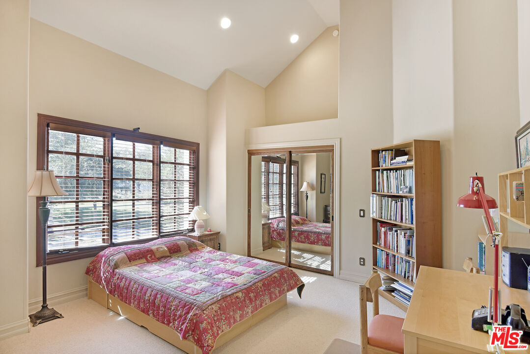 480 Westlake Boulevard Malibu, CA 90265 - Photo 21 of 36 a bedroom with a large bed and a book shelf